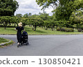 A young mother pushing a stroller during the rainy season 130850421