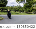 A young mother pushing a stroller during the rainy season - 2 130850422