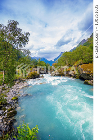 Beautiful mountain river Dalelva (Stryn). Cascade mountain stream with rapids. View from Briksdal Bridge Beautiful mountain river Dalelva (Stryn). Cascade mountain stream with rapids. View from Briksdal Bridge 130851635