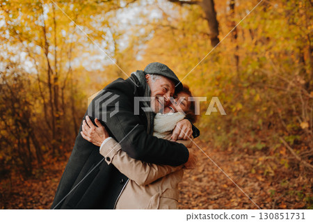 Older couple spending time outdoors in fall season. 130851731