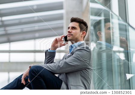 Young businessman making phone call indoors in an office. 130852301