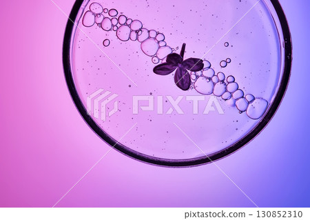 The texture of a cosmetic serum with a trail of bubbles on a purple background. 130852310