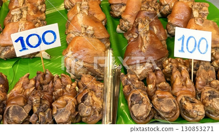 Asian street food. Exotic pork trotters, traditionally cooked and presented on banana leaves, signaling culinary adventure with bold flavors, tender textures, and authentic local dining experience 130853271