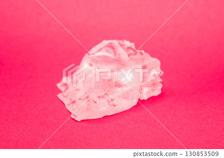 Large piece of crystal table salt on bright colored red background, close-up Large piece of crystal table salt on bright colored red background, close-up 130853509