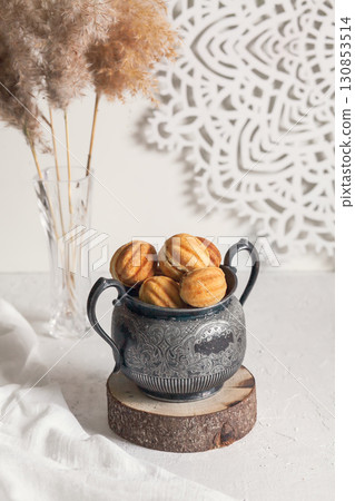 Russian traditional homemade cookies Nuts with condensed milk on an vintage jar on a wooden stand Russian traditional homemade cookies Nuts with condensed milk on an vintage jar on a wooden stand 130853514