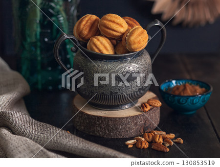 Russian traditional homemade cookies Nuts with condensed milk on vintage jar on wooden stand. Russian traditional homemade cookies Nuts with condensed milk on vintage jar on wooden stand. 130853519