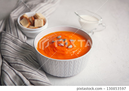 Pumpkin soup-puree with cream and seeds on a white background Pumpkin soup-puree with cream and seeds on a white background 130853597