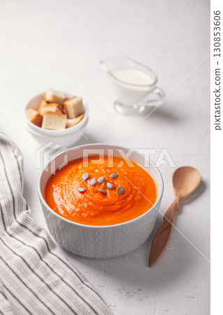 Pumpkin soup-puree with breadcrumbs, cream and seeds on a white background 130853606