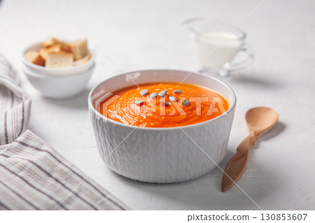 Pumpkin soup-puree with breadcrumbs, cream and seeds on a white background 130853607