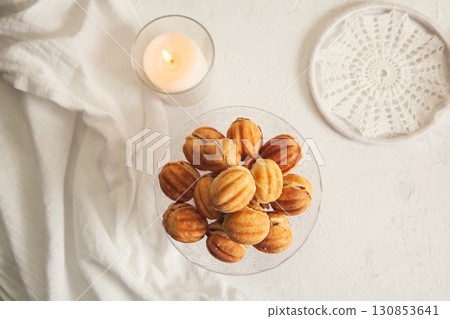 Russian traditional homemade cookies Nuts with condensed milk on a glass stand. White background, selective focus, top view Russian traditional homemade cookies Nuts with condensed milk on a glass stand. White background, selective focus, top view 130853641