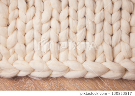 Blanket of thick yarn or merino wool plaid on floor. Background flat lay with copyspace Blanket of thick yarn or merino wool plaid on floor. Background flat lay with copyspace 130853817