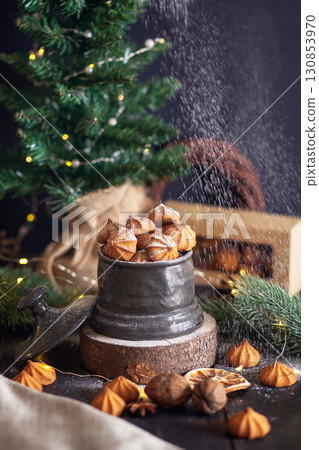 Cookies are sprinkled with powdered sugar - Christmas shortbread cookies in vintage jar on background of fir branches Cookies are sprinkled with powdered sugar - Christmas shortbread cookies in vintage jar on background of fir branches 130853970