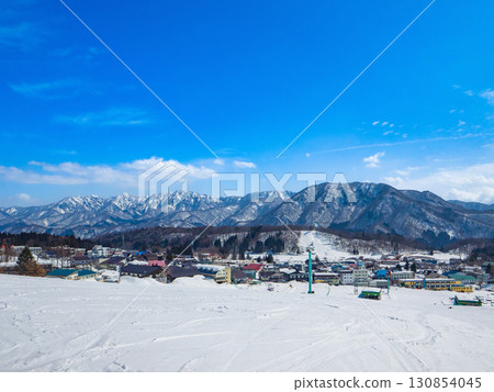 A vast ski slope and a hotel district at the foot of the mountain (Nagano Prefecture, Hakuba, Tsugaike Kogen, Bell-ringing Hill Ski Slope) A vast ski slope and a hotel district at the foot of the mountain (Nagano Prefecture, Hakuba, Tsugaike Kogen, Bell-ringing Hill Ski Slope) 130854045