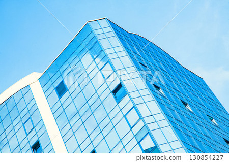 Part of the building with glazed windows against the sky Part of the building with glazed windows against the sky 130854227