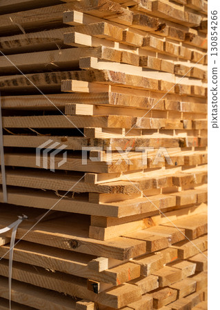 Stack of wooden planks at sawmill storage close up construction lumber background Stack of wooden planks at sawmill storage close up construction lumber background 130854266