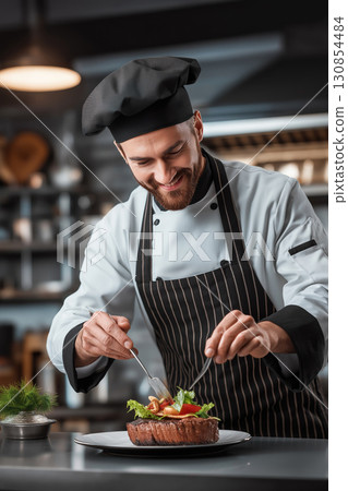 A chef dressed in a white uniform garnishes food with fresh ingredients 130854484