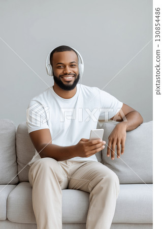 Man enjoying music while using smartphone at home 130854486