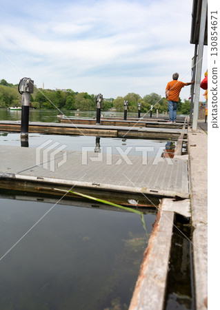 Berth for boats. A man stands by the water Berth for boats. A man stands by the water 130854671