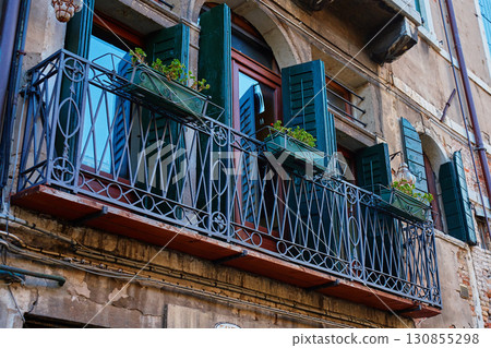 Flower pots on window of old Venetian building Flower pots on window of old Venetian building 130855298