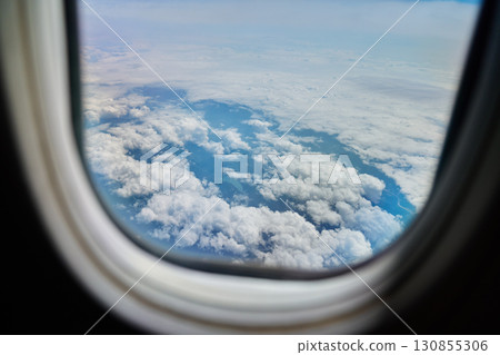 View of clouds through airplane window during flight 130855306