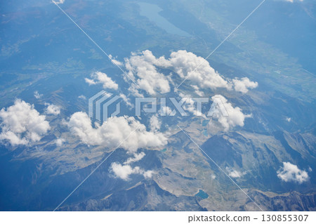 Aerial view of mountains and clouds from airplane window 130855307