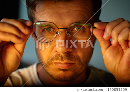 Man looking through glasses at camera 130855309