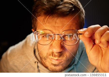 Man looking through glasses at camera 130855311