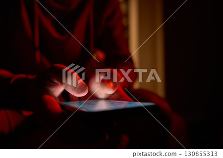 Hand using smartphone in dark room 130855313