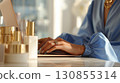 A closeup of a woman's hands typing on a laptop surrounded by white minimalist beauty products.  130855314