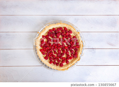 Preparation of shortbread pie with raspberries on white wooden background, top view 130855667