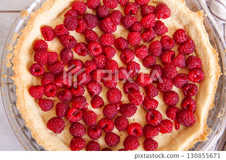 Preparation of shortbread pie with raspberries on a white wooden background, top view close up 130855671