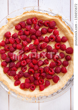 Preparation of shortbread pie with raspberries on a white wooden background, top view 130855672