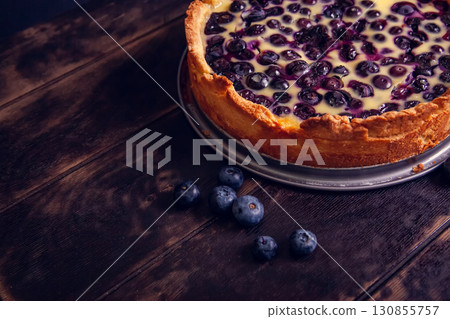Rustic shortbread pie with blueberries in sour cream filling on a wooden background. Close up 130855757
