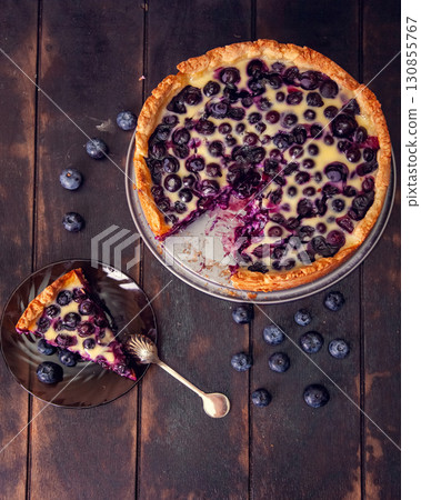 Rustic shortbread pie with blueberries in sour cream filling on a wooden background. Top view flat lay 130855767
