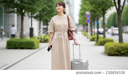 一名女子提著手提箱行走 130856326