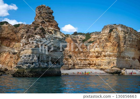 View of Algarve Portugal coastal ocean cliffs caves grottos beaches with people from boat View of Algarve Portugal coastal ocean cliffs caves grottos beaches with people from boat 130856663