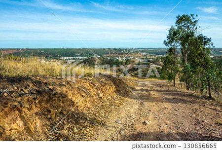 Idyllic landscape with medieval castle seen from dirt path Via Algarviana hiking trail Portugal Idyllic landscape with medieval castle seen from dirt path Via Algarviana hiking trail Portugal 130856665