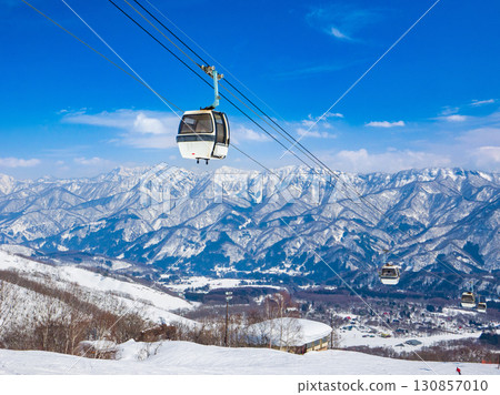 一輛纜車在藍天白雲下沿著晴朗的滑雪坡道上昇(長野縣白馬村櫂池高原) 一輛纜車在藍天白雲下沿著晴朗的滑雪坡道上昇(長野縣白馬村櫂池高原) 130857010