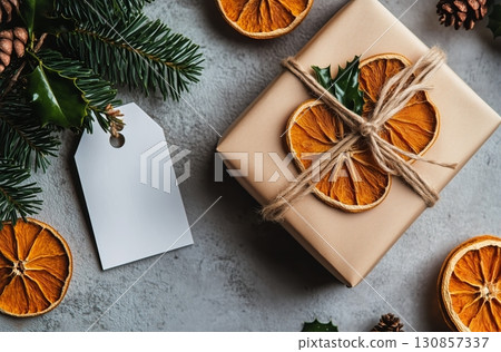 Festive Gift Wrapping With Dried Orange Slices and Pinecones on a Rustic Surface. 130857337