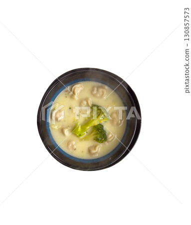Broccoli cream soup in a black bowl on a white background Broccoli cream soup in a black bowl on a white background 130857573