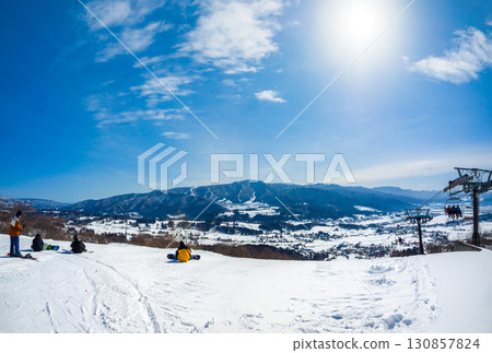 滑雪愛好者在滑雪場休息，欣賞白雪皚皚的街道和山脈（長野縣飯山市戶漾溫泉） 130857824