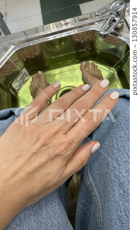 Pedicure and manicure session with female hands and feet submerged in spa water for relaxation Pedicure and manicure session with female hands and feet submerged in spa water for relaxation 130857914