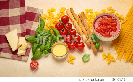 Italian food cuisine background featuring tomato sauce, grissini, pasta, parmesan, fresh basil Italian food cuisine background featuring tomato sauce, grissini, pasta, parmesan, fresh basil 130857963