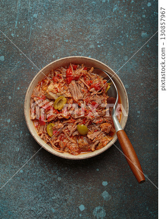 Ropa vieja with white rice, tomato sauce and green olives on a plate top view, traditional dish of Cuba 130857967