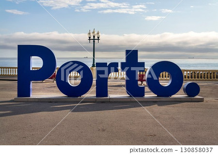 Blue three-dimensional Porto sign on promenade along the coast and beach, Portugal, sunset on sunny summer day Blue three-dimensional Porto sign on promenade along the coast and beach, Portugal, sunset on sunny summer day 130858037