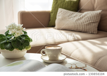 Cozy Living Room Scene with Coffee, Book and African Violet 130858104