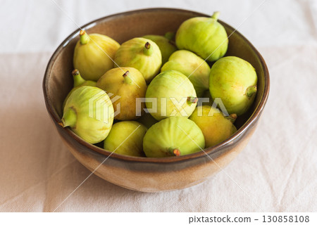 Fresh Green Figs in Ceramic Bowl on Light Fabric Background Fresh Green Figs in Ceramic Bowl on Light Fabric Background 130858108