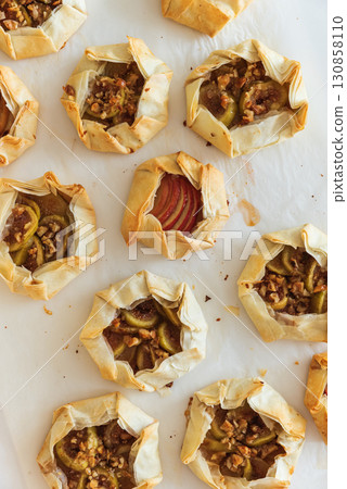 Rustic Fruit Galettes with Honey and Nuts on White Background. Top view 130858110