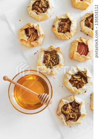 Rustic Fruit Galettes with Honey and Nuts on White Background. Top view 130858112