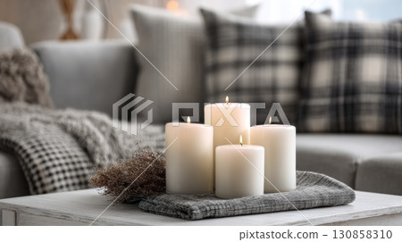 Cozy home interior with burning candles on a coffee table 130858310